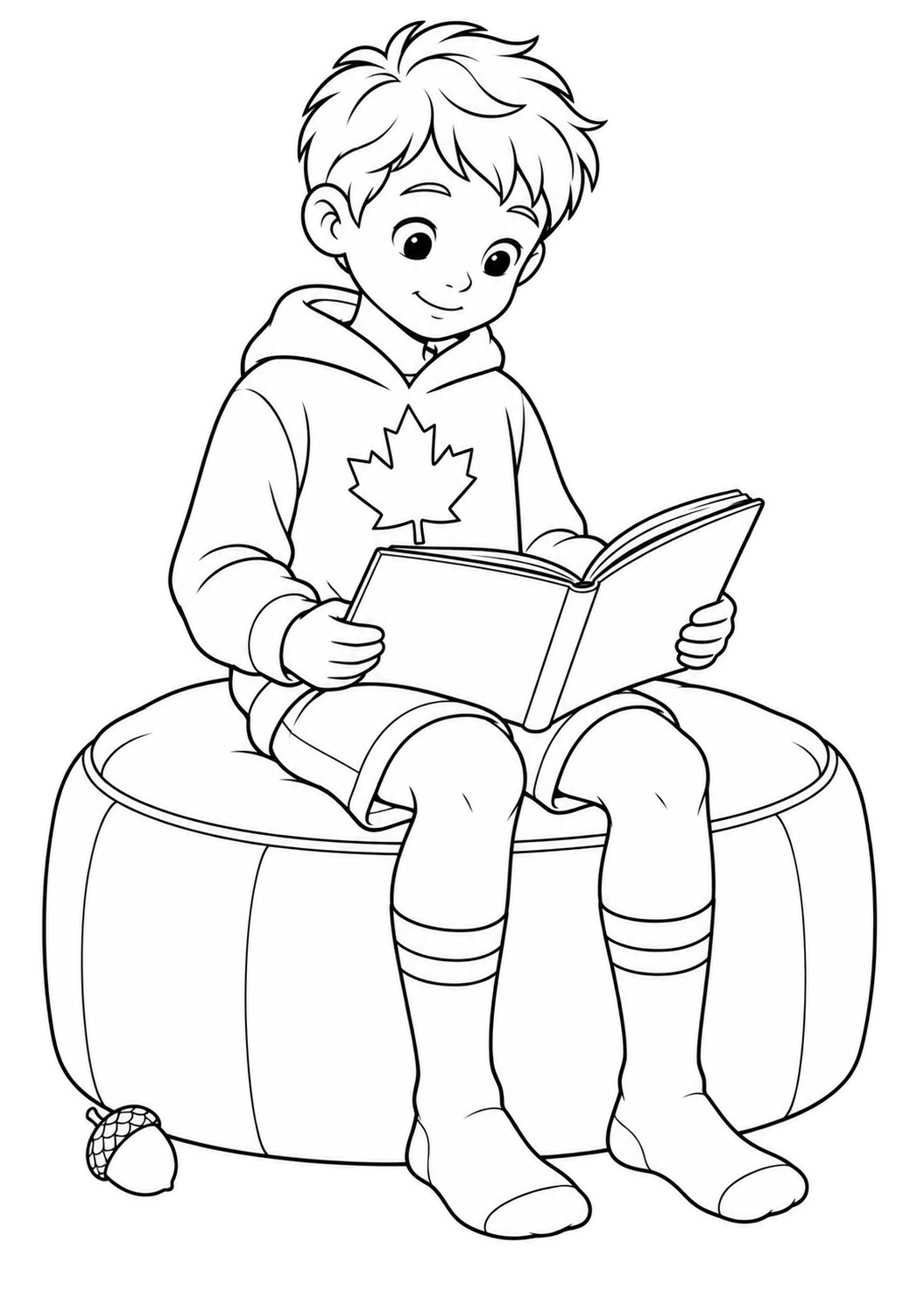 Junge mit Ahornblatt-Hoodie, Shorts und Ringelsocken hält ein Buch auf einem runden Polsterhocker, daneben liegt eine Eichel.